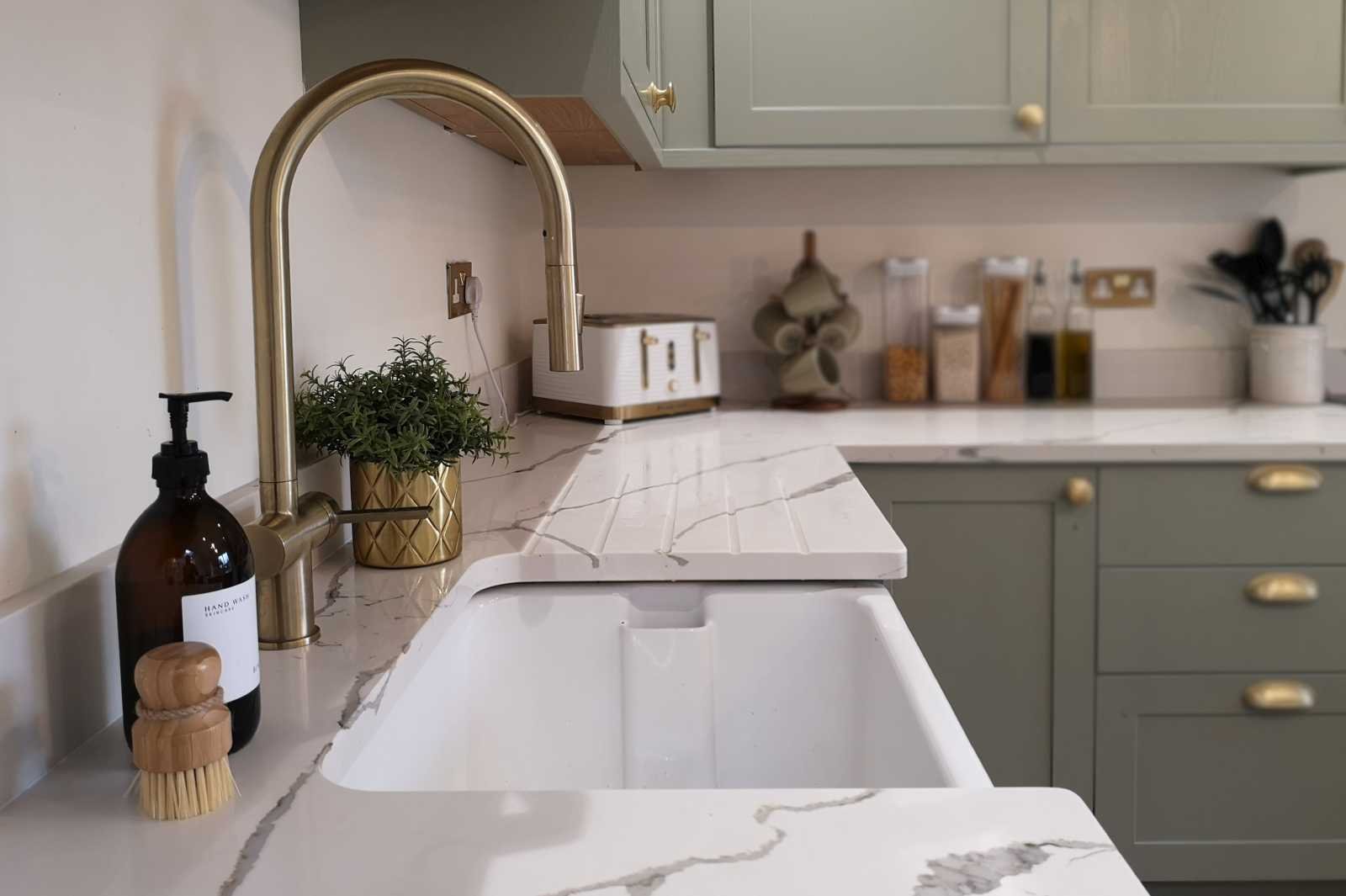 contemporary shaker style kitchen close up of belfast sink and brass tap