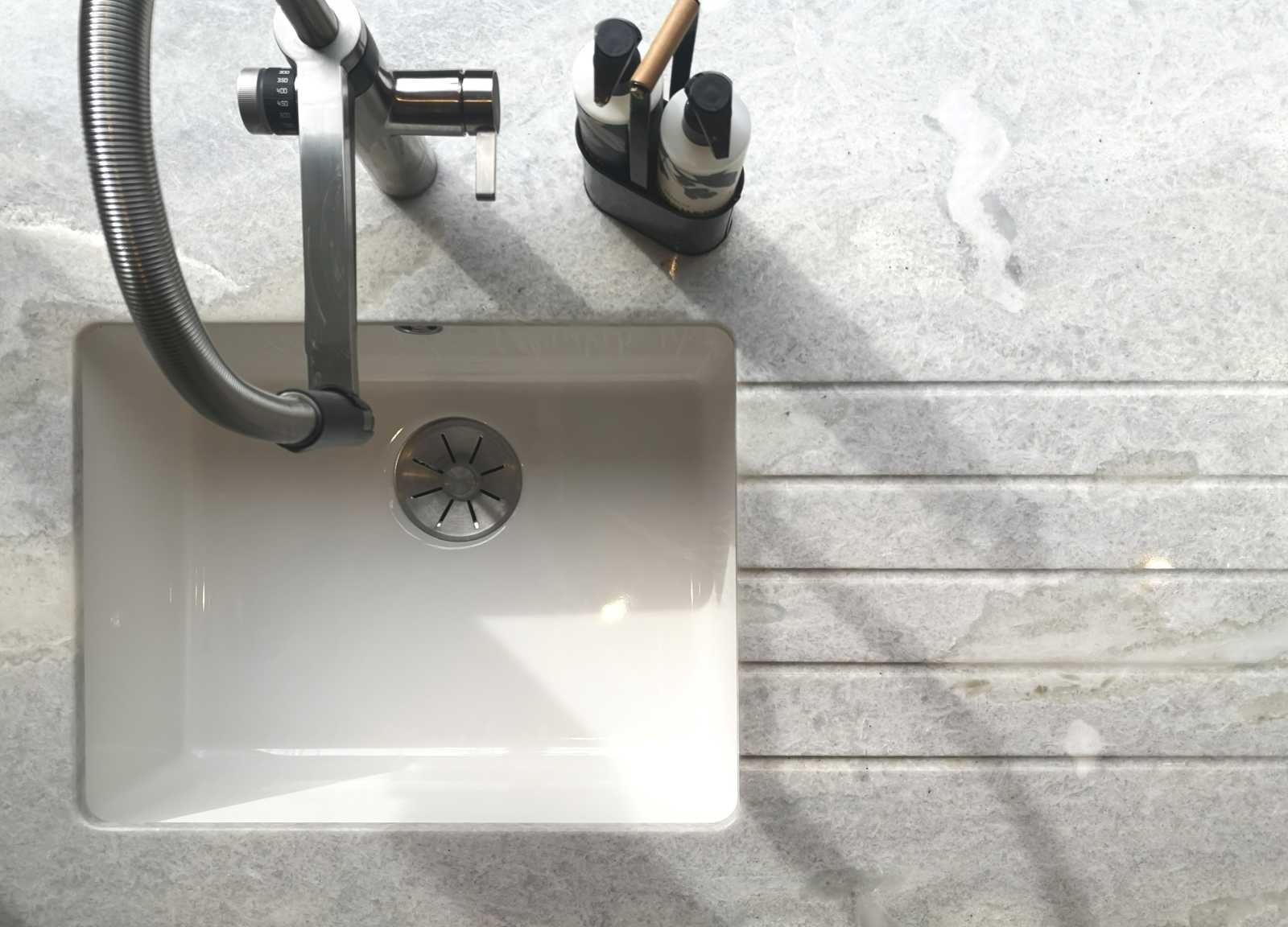Blanco undermount sink and hot water tap with drainage grooves in worktop 