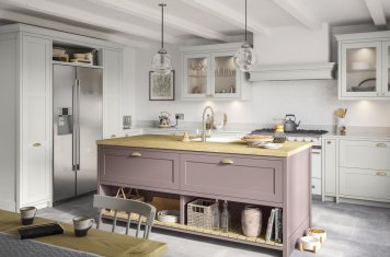 Smooth-finish, slim-frame, shaker-style kitchen painted vintage pink and light grey featuring central island unit, american fridge freezer, range cooker and canopy housing a recessed extractor fan